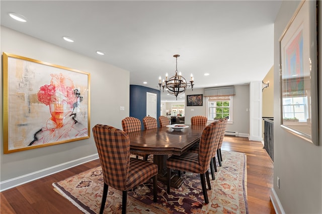 dining area with baseboard heating, an inviting chandelier, and dark wood-type flooring