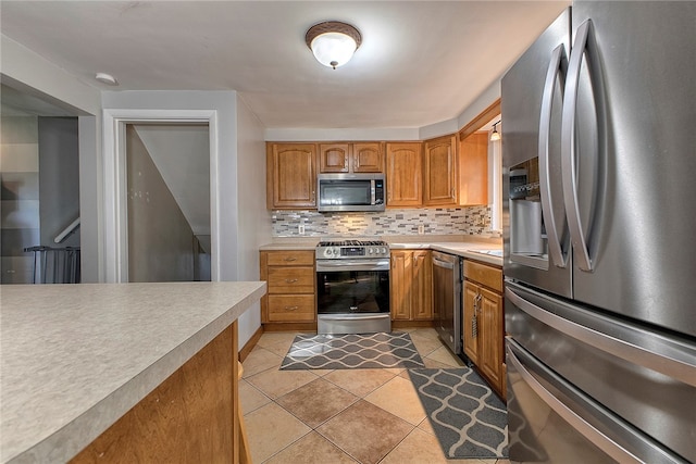 kitchen featuring light tile patterned flooring, stainless steel appliances, and tasteful backsplash