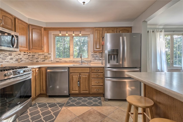 kitchen with decorative backsplash, sink, stainless steel appliances, and plenty of natural light