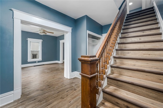 stairway featuring hardwood / wood-style floors and ceiling fan