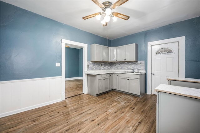 kitchen featuring tasteful backsplash, sink, light hardwood / wood-style flooring, gray cabinetry, and ceiling fan