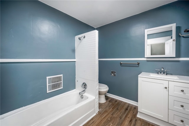 full bathroom with washtub / shower combination, vanity, toilet, and hardwood / wood-style flooring