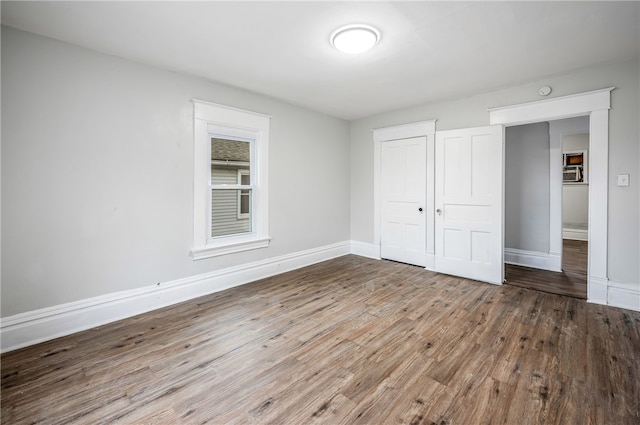 unfurnished bedroom with a closet and hardwood / wood-style floors