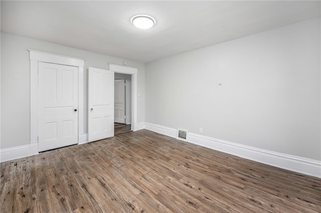 unfurnished bedroom featuring a closet and hardwood / wood-style flooring