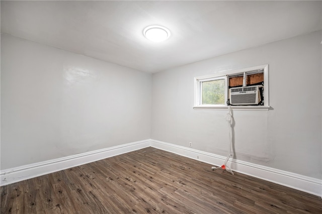 unfurnished room featuring cooling unit and dark hardwood / wood-style flooring