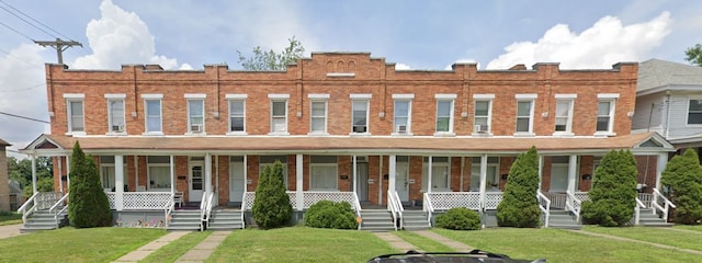 view of property featuring a porch and a front yard