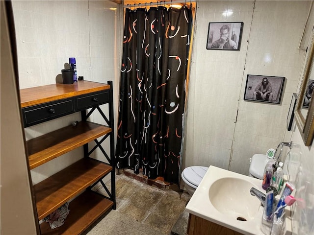 bathroom featuring walk in shower, sink, tile walls, and toilet