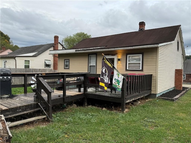 back of property with a lawn and a wooden deck