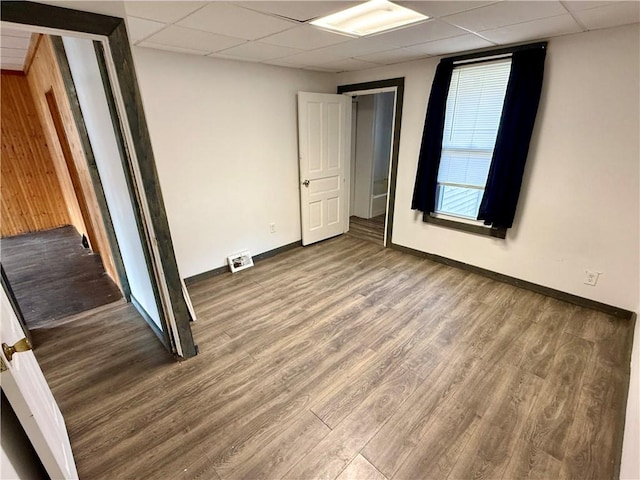 unfurnished room featuring wood-type flooring and a paneled ceiling