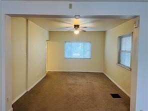 unfurnished room featuring dark colored carpet and ceiling fan