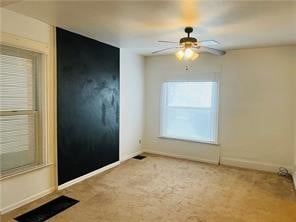 carpeted empty room featuring ceiling fan