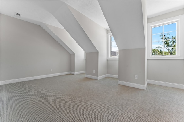 bonus room featuring light carpet and vaulted ceiling