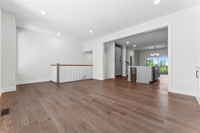 unfurnished room featuring a chandelier and dark hardwood / wood-style flooring