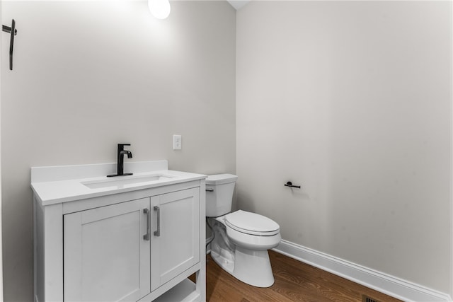 bathroom featuring hardwood / wood-style floors, vanity, and toilet