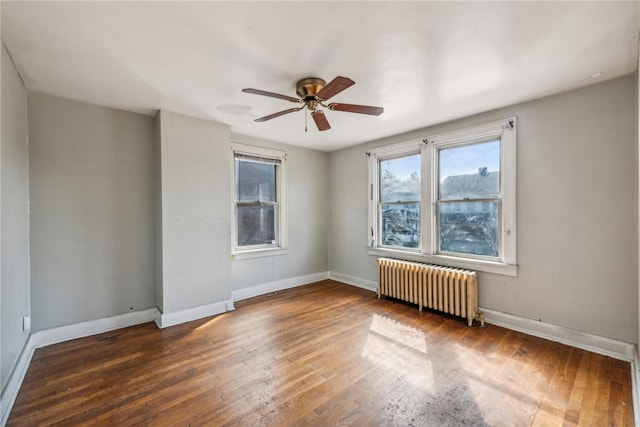 unfurnished room featuring dark hardwood / wood-style floors, radiator, and ceiling fan