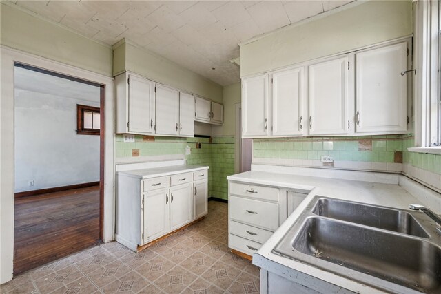 kitchen with light hardwood / wood-style floors, tasteful backsplash, sink, and white cabinets