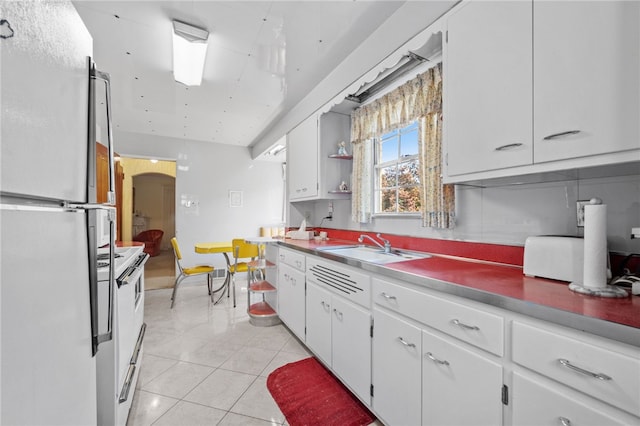 kitchen featuring white appliances, white cabinetry, and light tile patterned flooring