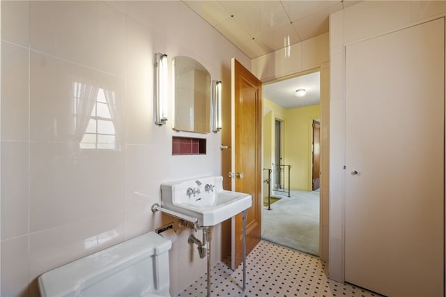 bathroom with tile walls and toilet