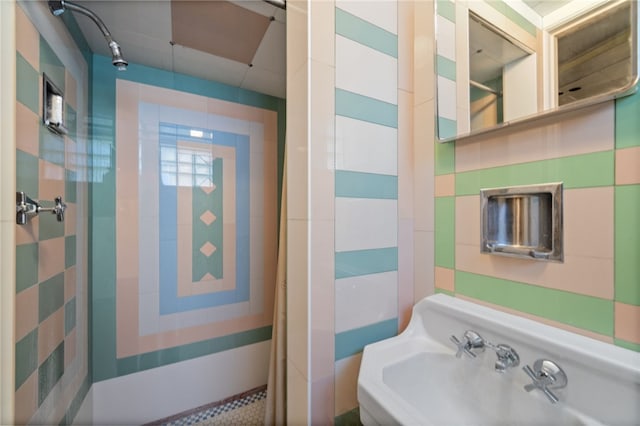 bathroom with a tile shower and sink