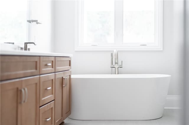 bathroom with a bathtub, tile patterned flooring, and vanity