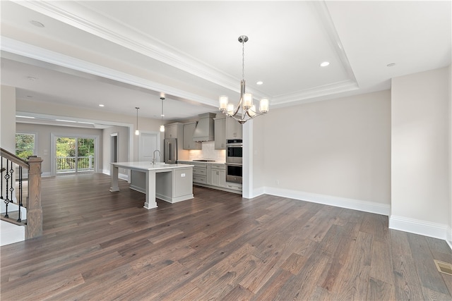 interior space with ornamental molding, a raised ceiling, a chandelier, and dark hardwood / wood-style flooring