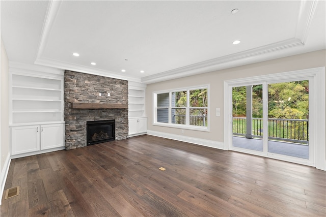 unfurnished living room with a fireplace, ornamental molding, built in shelves, and hardwood / wood-style flooring