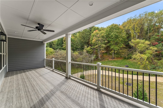 wooden terrace with ceiling fan and a yard