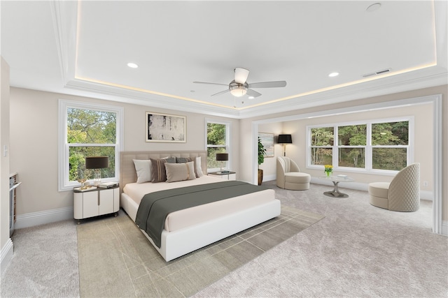 bedroom with ornamental molding, a tray ceiling, ceiling fan, and light colored carpet