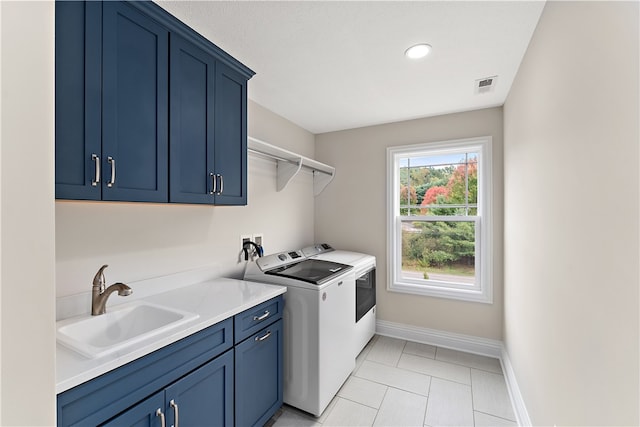 clothes washing area with light tile patterned floors, cabinets, sink, and washing machine and clothes dryer