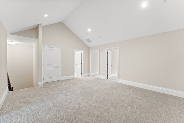 carpeted empty room featuring high vaulted ceiling