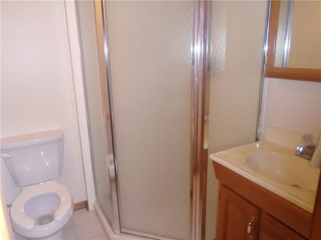 full bath with toilet, vanity, tile patterned flooring, and a stall shower