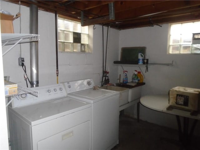 laundry area with concrete block wall, laundry area, a sink, and separate washer and dryer