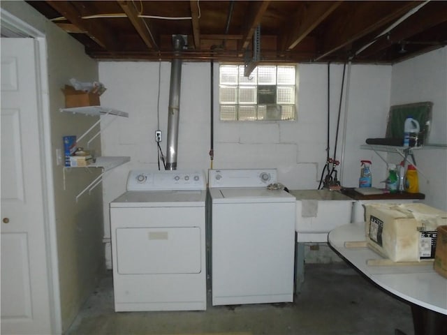 clothes washing area featuring washing machine and dryer, a sink, and laundry area