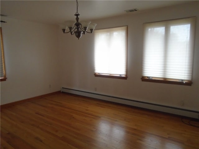 unfurnished room with a chandelier, baseboard heating, and dark wood-type flooring