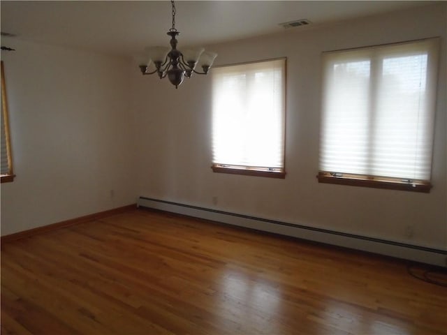 unfurnished room with baseboard heating, visible vents, a chandelier, and a healthy amount of sunlight