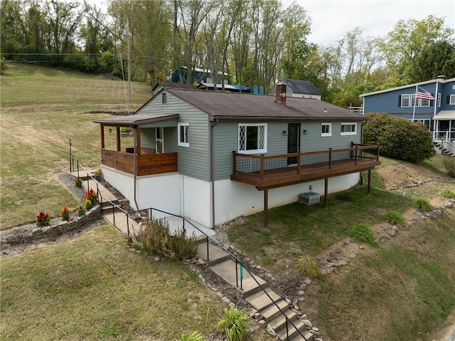 back of house with a lawn and a wooden deck