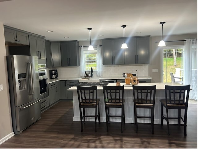 kitchen featuring pendant lighting, stainless steel appliances, and a wealth of natural light