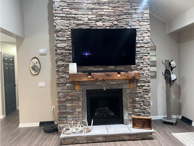 interior details with hardwood / wood-style floors and a stone fireplace