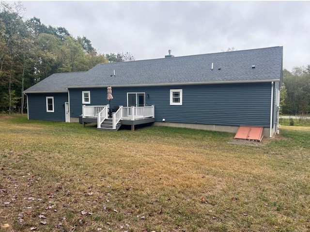 rear view of property with a yard and a wooden deck