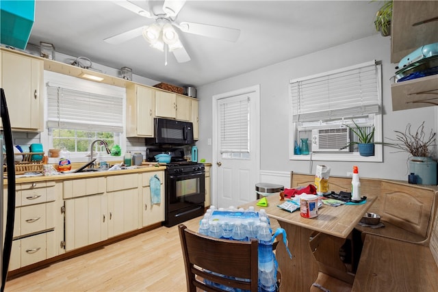 kitchen featuring light hardwood / wood-style floors, sink, cooling unit, black appliances, and ceiling fan