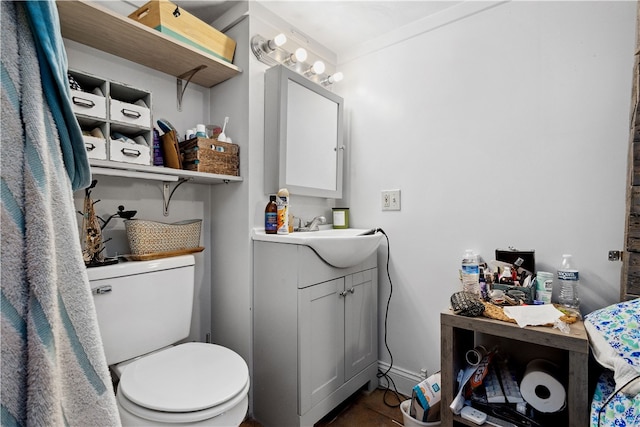 bathroom featuring ornamental molding, vanity, and toilet