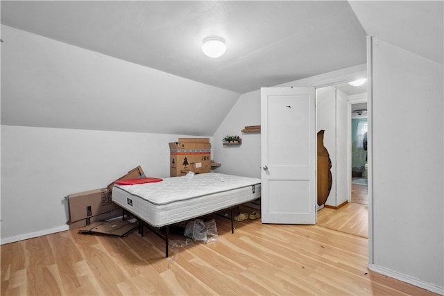 bedroom with hardwood / wood-style flooring and lofted ceiling