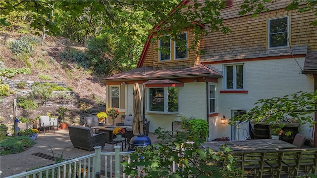 back of house with an outdoor living space and a patio