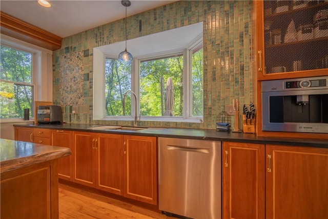 1487 Beaver Rd, Sewickley, PA 15143 - kitchen featuring dark countertops, a sink, brown cabinets, stainless steel appliances, and light wood-style flooring
