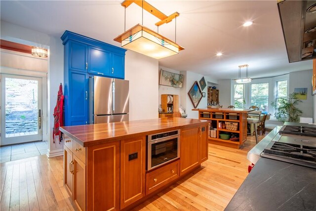 1487 Beaver Rd, Sewickley, PA 15143 - kitchen featuring blue cabinets, stainless steel refrigerator, butcher block counters, light wood-style floors, and hanging light fixtures