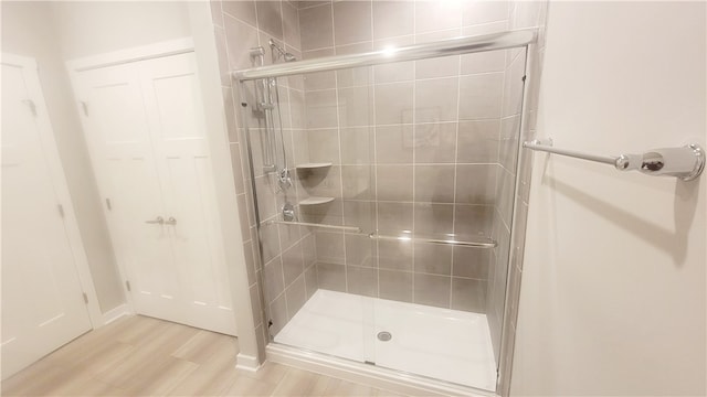 bathroom with walk in shower and hardwood / wood-style floors