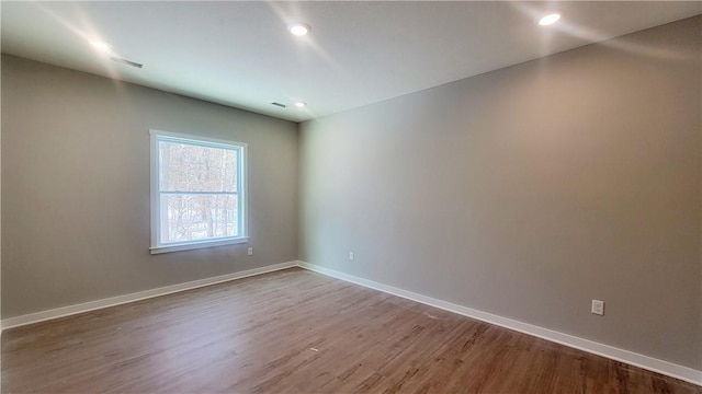 unfurnished room featuring wood finished floors, baseboards, and recessed lighting
