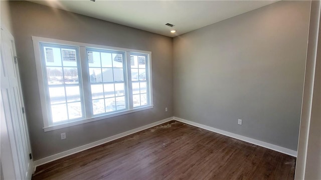 unfurnished room featuring dark wood-style flooring and baseboards