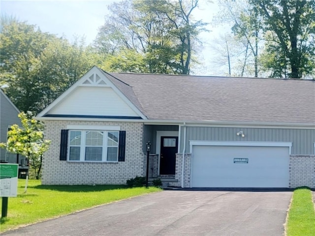 view of front of property with brick siding, driveway, an attached garage, a front yard, and roof with shingles