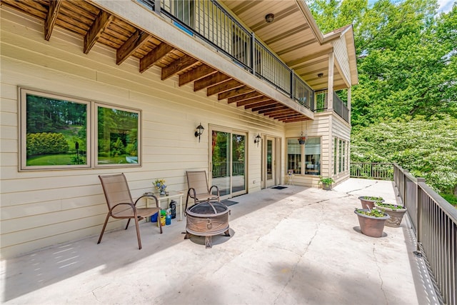 view of patio / terrace featuring a balcony and an outdoor fire pit